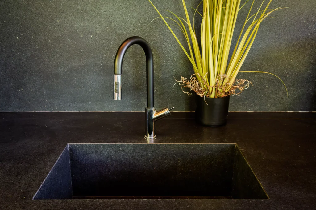 Wood and stone outdoor kitchen surrounded by greenery, designed by Vitelier at Club de Golf Avándaro, State of Mexico.