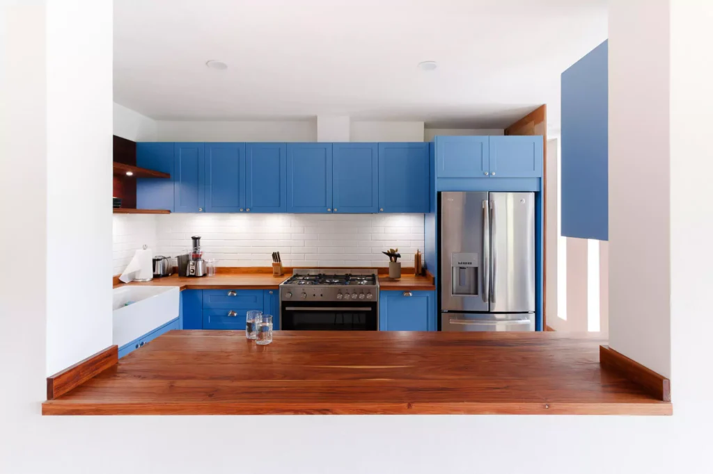 Traditional-style blue lacquered kitchen with wooden countertop, designed by Vitelier at Fontana Chica, Avándaro, State of Mexico.