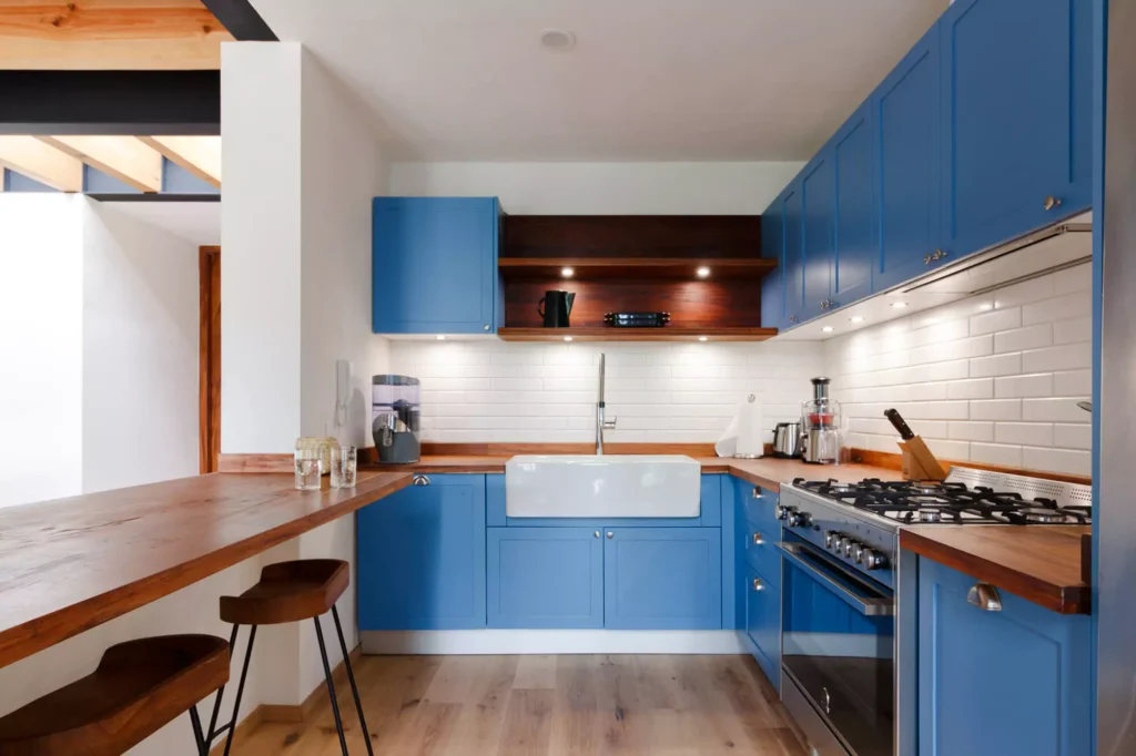 Traditional-style blue lacquered kitchen with wooden countertop, designed by Vitelier at Fontana Chica, Avándaro, State of Mexico.