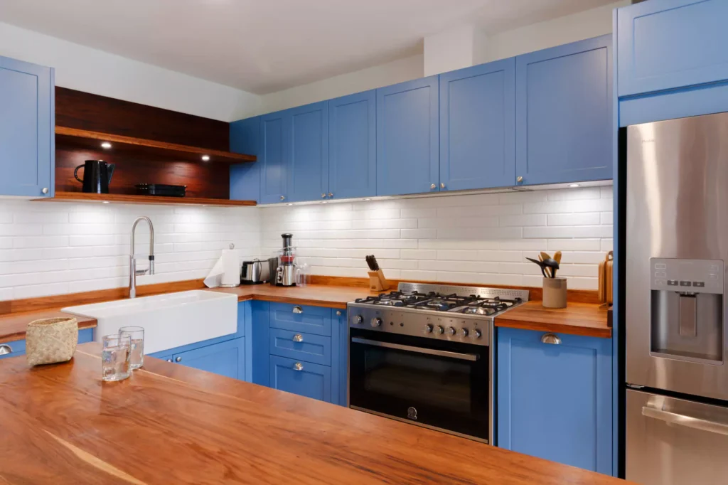 Traditional-style blue lacquered kitchen with wooden countertop, designed by Vitelier at Fontana Chica, Avándaro, State of Mexico.