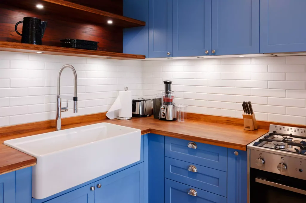 Traditional-style blue lacquered kitchen with wooden countertop, designed by Vitelier at Fontana Chica, Avándaro, State of Mexico.