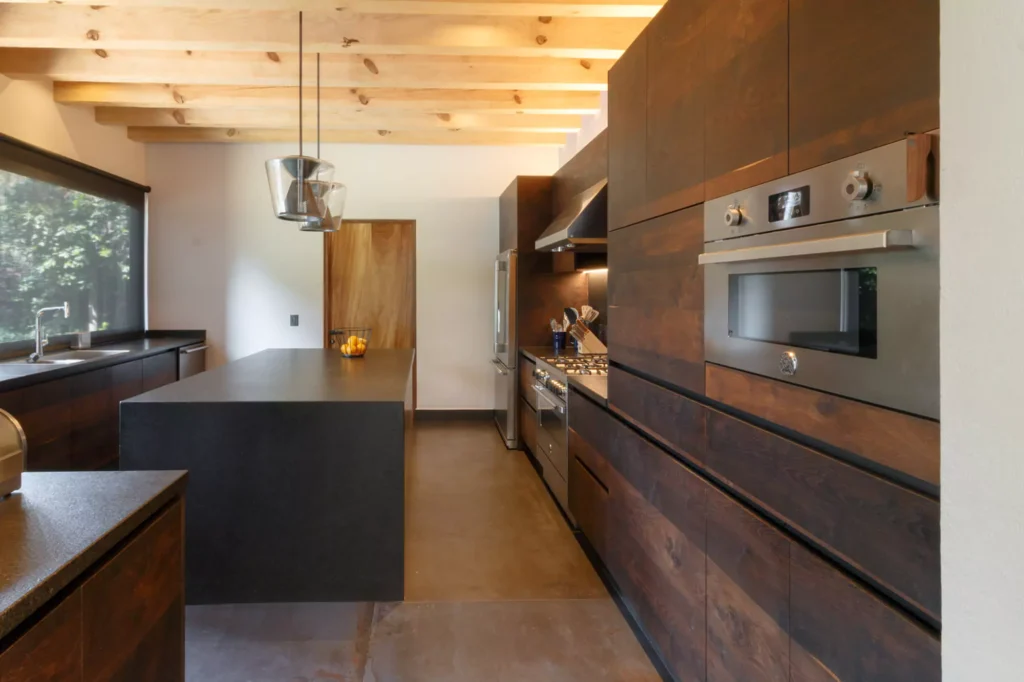 Industrial-style wooden kitchen with granite central island designed by Vitelier in Avándaro, State of Mexico