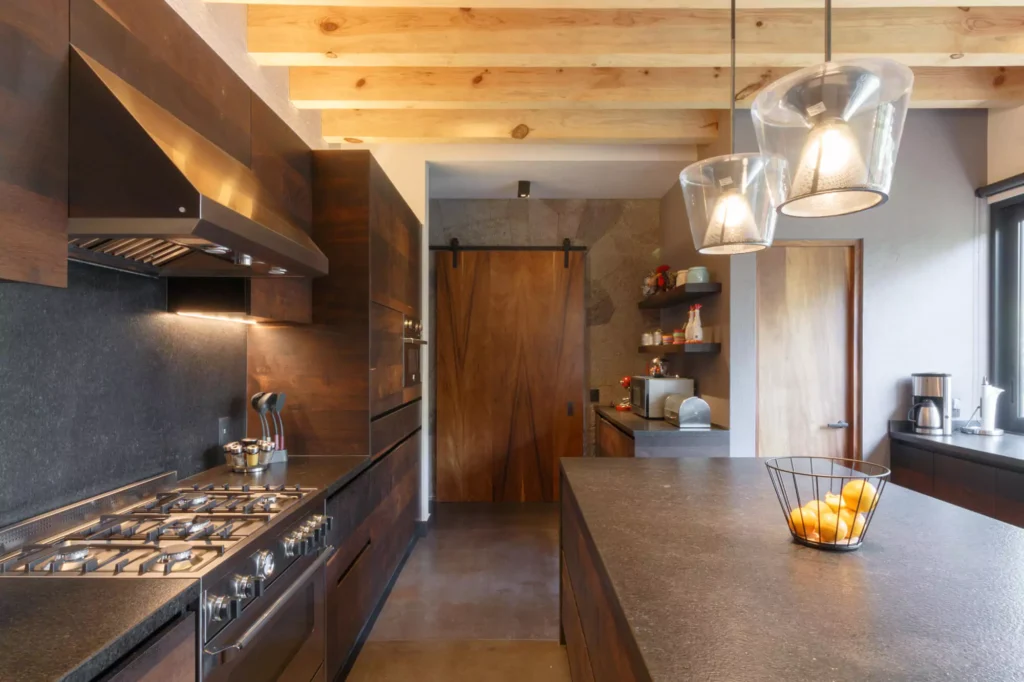 Industrial-style wooden kitchen with granite central island designed by Vitelier in Avándaro, State of Mexico