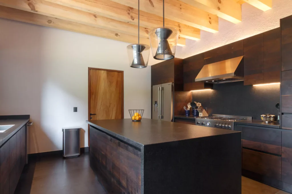 Industrial-style wooden kitchen with granite central island designed by Vitelier in Avándaro, State of Mexico