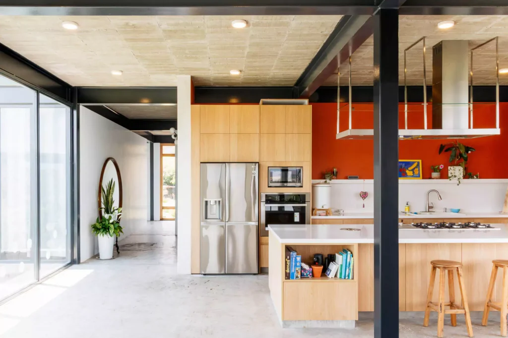 Wooden kitchen with island and stainless steel range hood, designed by Vitelier at Casa Tortuga in Valle de Bravo.