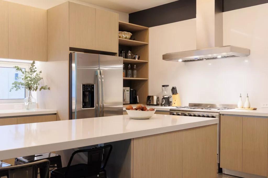 Modern kitchen with wood veneer and central island, designed by Vitelier at Granados, Colonia Bosques de las Lomas, Mexico City.