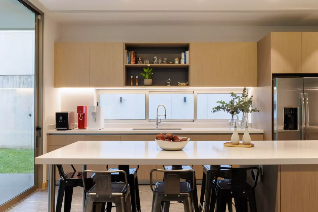 Modern kitchen with wood veneer and central island, designed by Vitelier at Granados, Colonia Bosques de las Lomas, Mexico City.