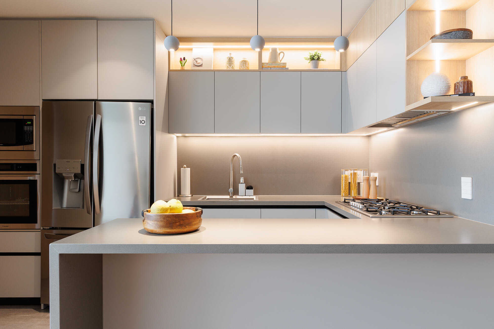Cocina gris modular abierta con puertas laminadas y cubierta de cuarzo