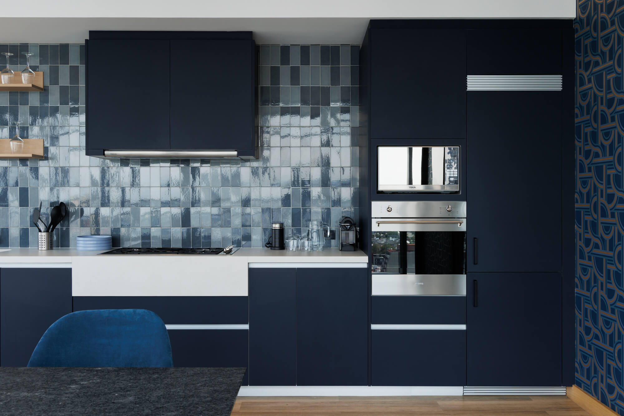 Cocina azul marino con azulejos y campana