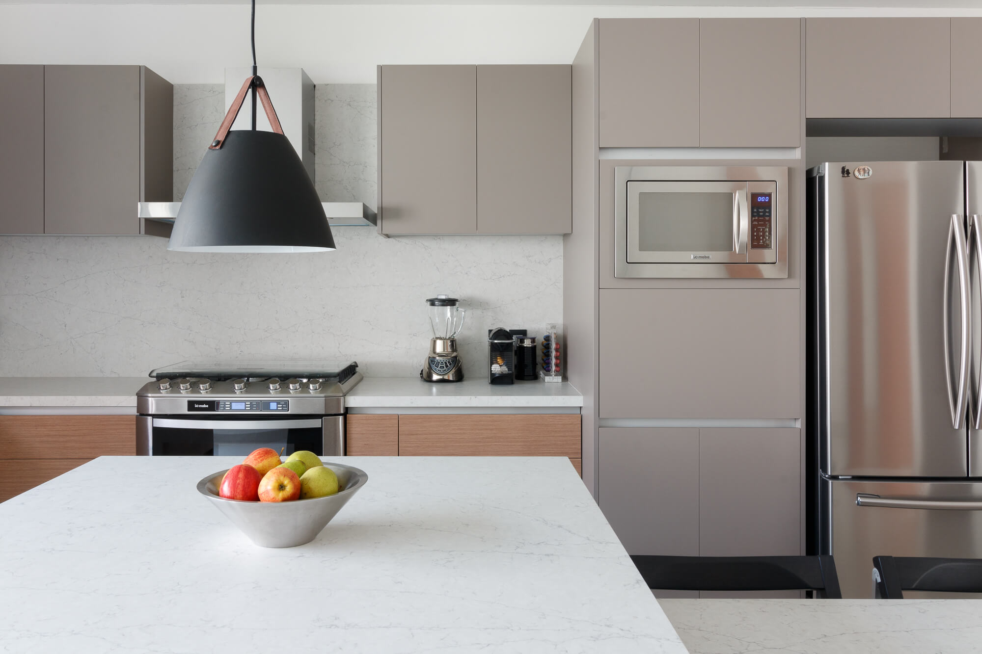 Cocina gris modular con isla con cubierta de piedra tipo mármol