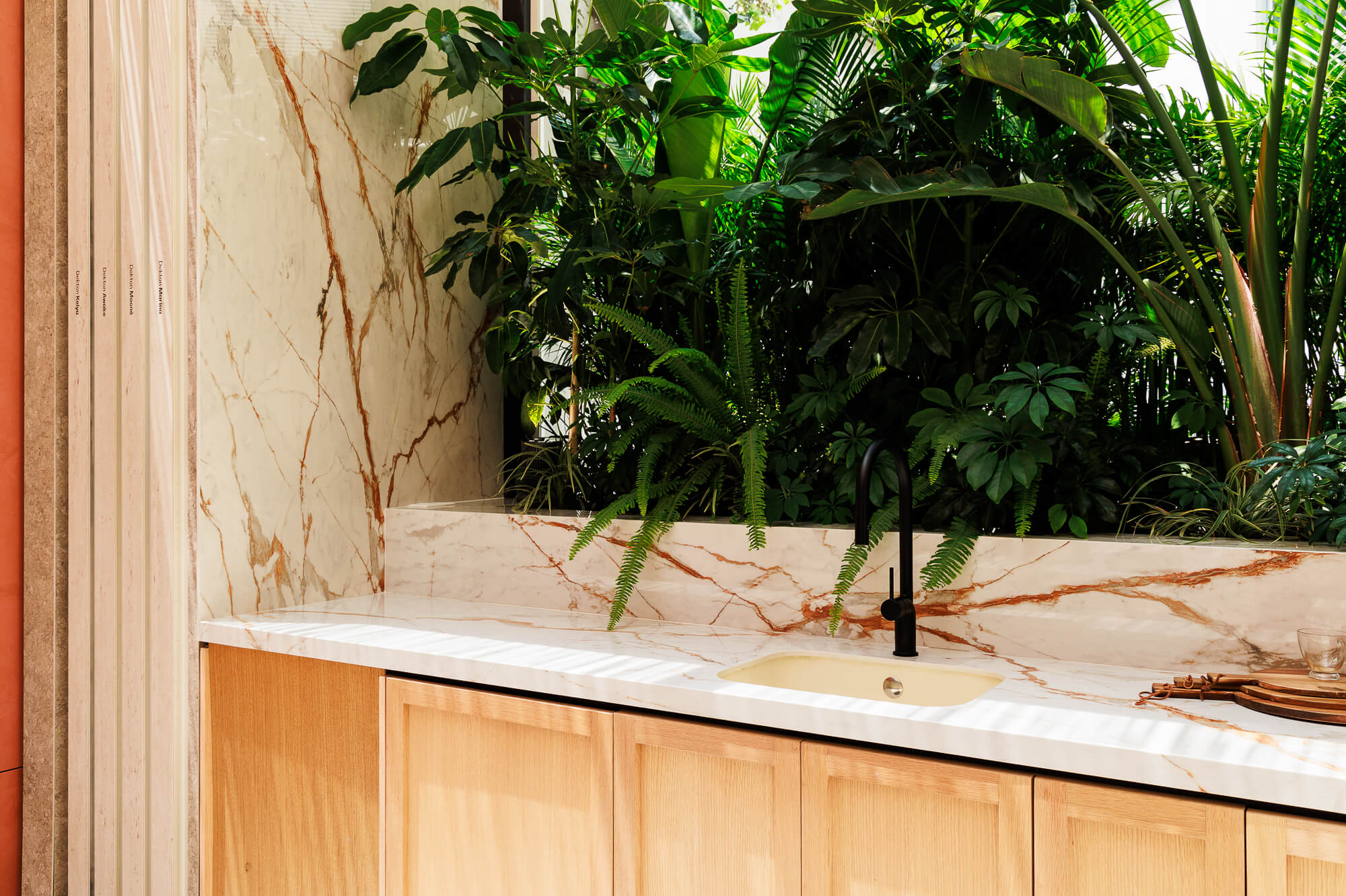 Cocina con plantas y cubierta Dekton de Cosentino y frentes de chapa de encino natural.