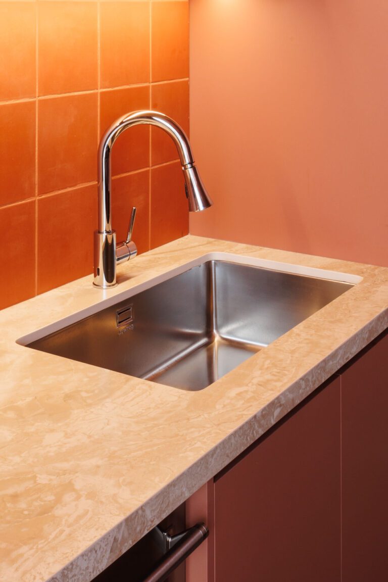 Tarja de acero inoxidable en una cocina roja.