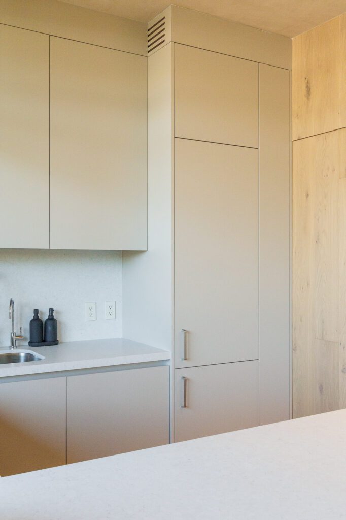 Refrigerador panelable, con la puerta cerrada, en una cocina minimalista color beige.