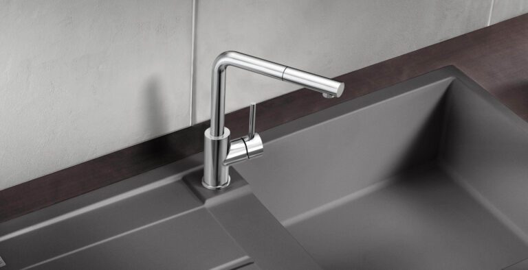 Llave ahorradora de agua Linus de Blanco en acabado cromado sobre tarja para cocina gris oscura.