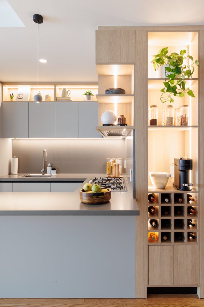 Diseño de cocina modular color gris con mueble de nichos de madera e iluminación