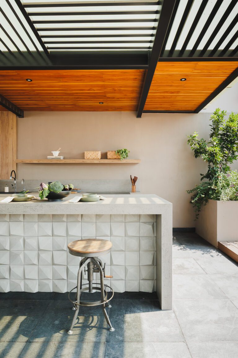 Diseño de cocina exterior en terraza con barra y techo de madera.