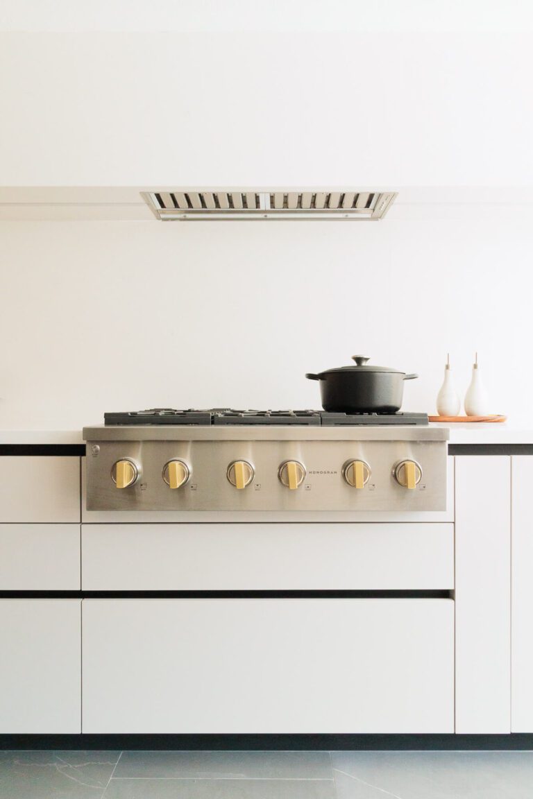 Cocina moderna con estufa integrada y frentes en acabado mate con melamina en color beige claro.