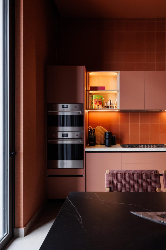 Cocina roja burdeos monocromática con azulejos y mesa de comedor negra