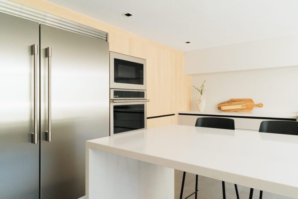 Cocina minimalista con barra y refrigerador de acero inoxidable