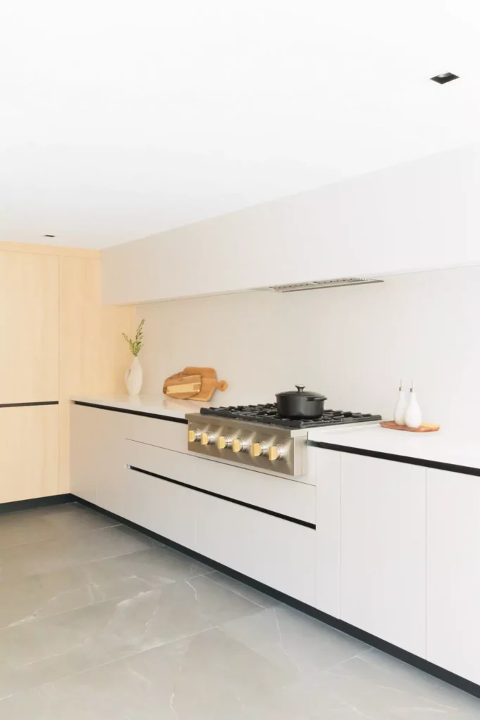 Cocina sin jaladeras minimalista blanca con madera clara