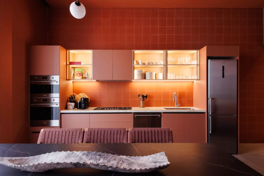 Cocina funcional roja con iluminación puntual en nichos y gabinetes