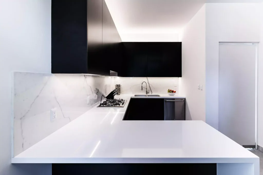 Moderna cocina blanca y negra con barra, parrilla y gabinetes flotantes