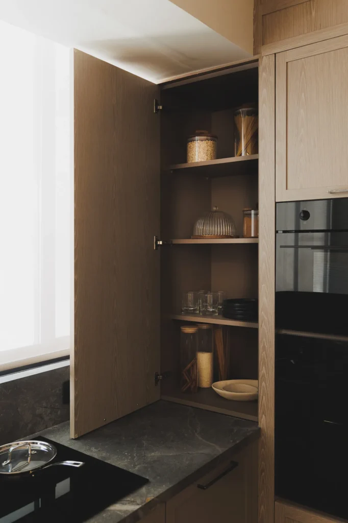 Storage cabinet in a patina wood kitchen with sintered stone countertop