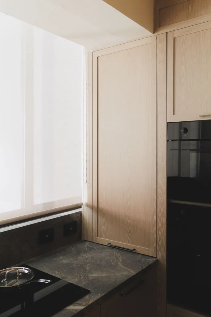 Storage cabinet in a patina wood kitchen with sintered stone countertop