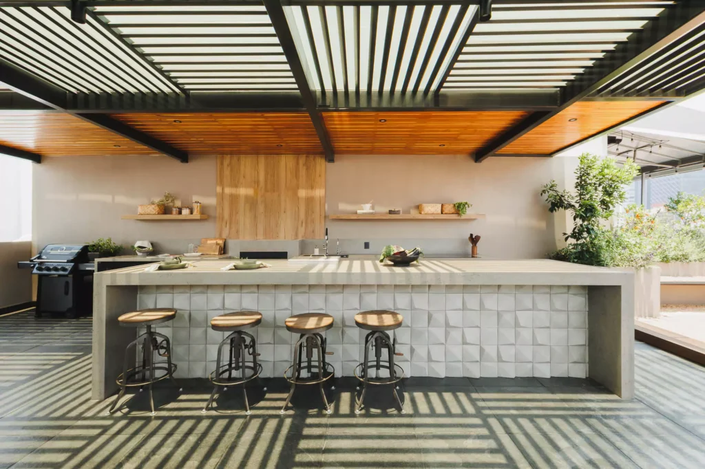 Cocina exterior con isla y pérgola