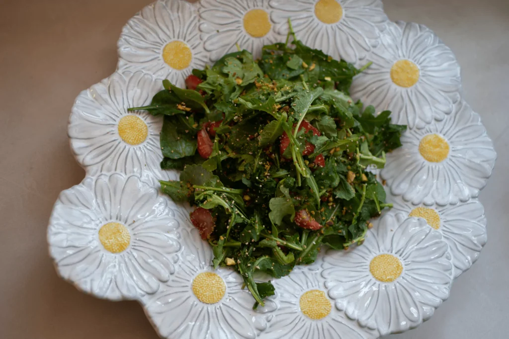 Ensalada de arúgula servido en un platón de margaritas de Zash