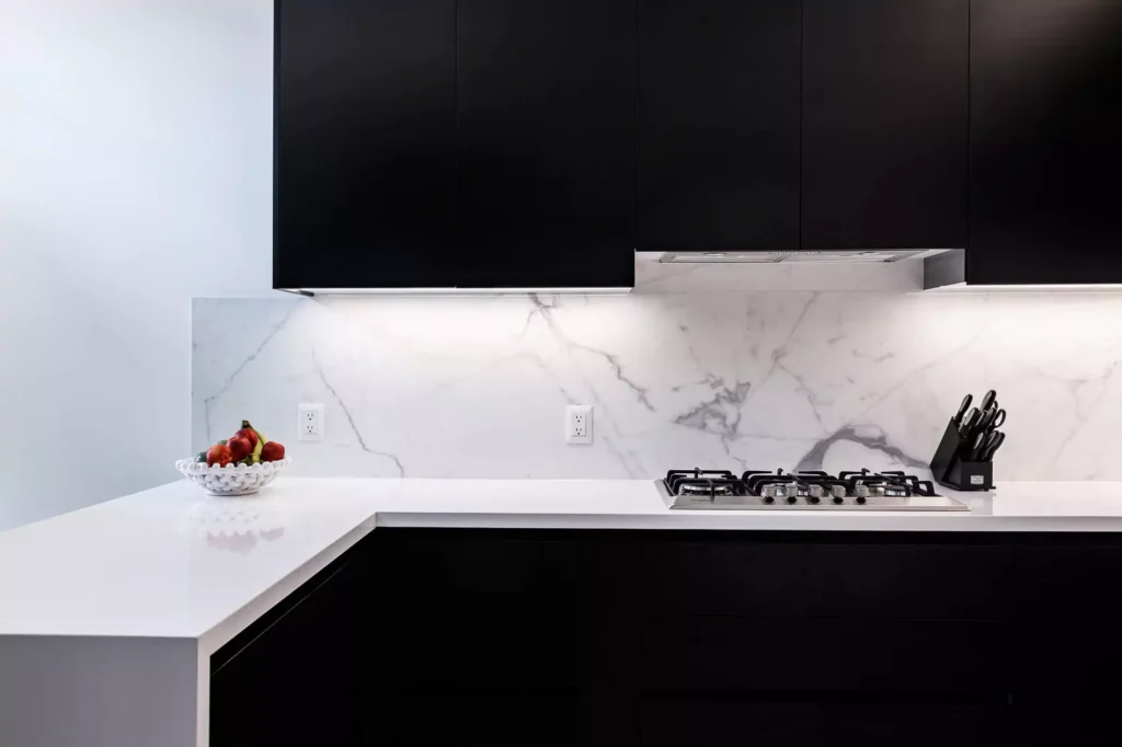 Black and white kitchen with contrasting countertop materials and floating cabinets designed by Vitelier