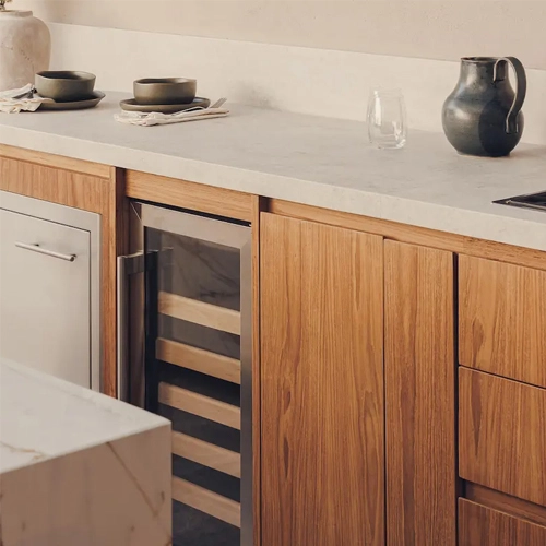 Cocina de teca con cubierta de piedra sinterizada, cava de vinos integrada y parrilla de gas en el proyecto Schiller diseñado por Vitelier en Ciudad de México