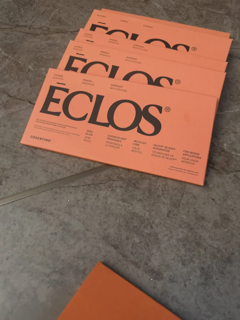Folletos de Éclos de Cosentino sobre superficie de mármol con especificaciones técnicas INLAYR