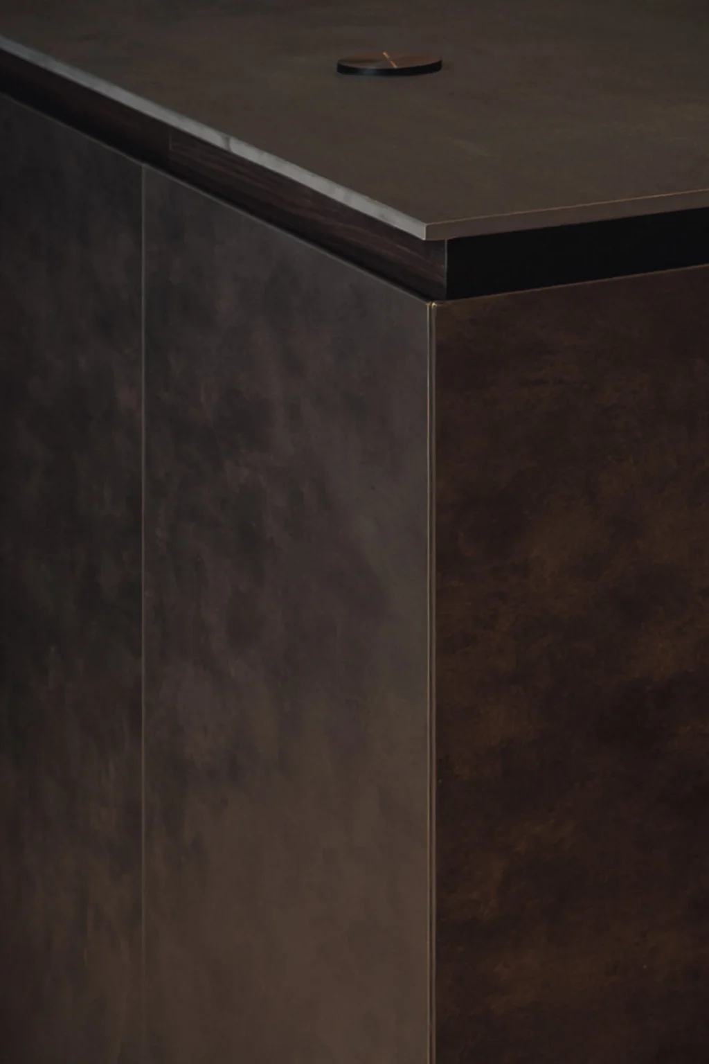 Detail of the junction between the Dekton Bromo countertop and the Cymisa metallic sheet fronts with aged finish — central island at Proyecto Público Prim.