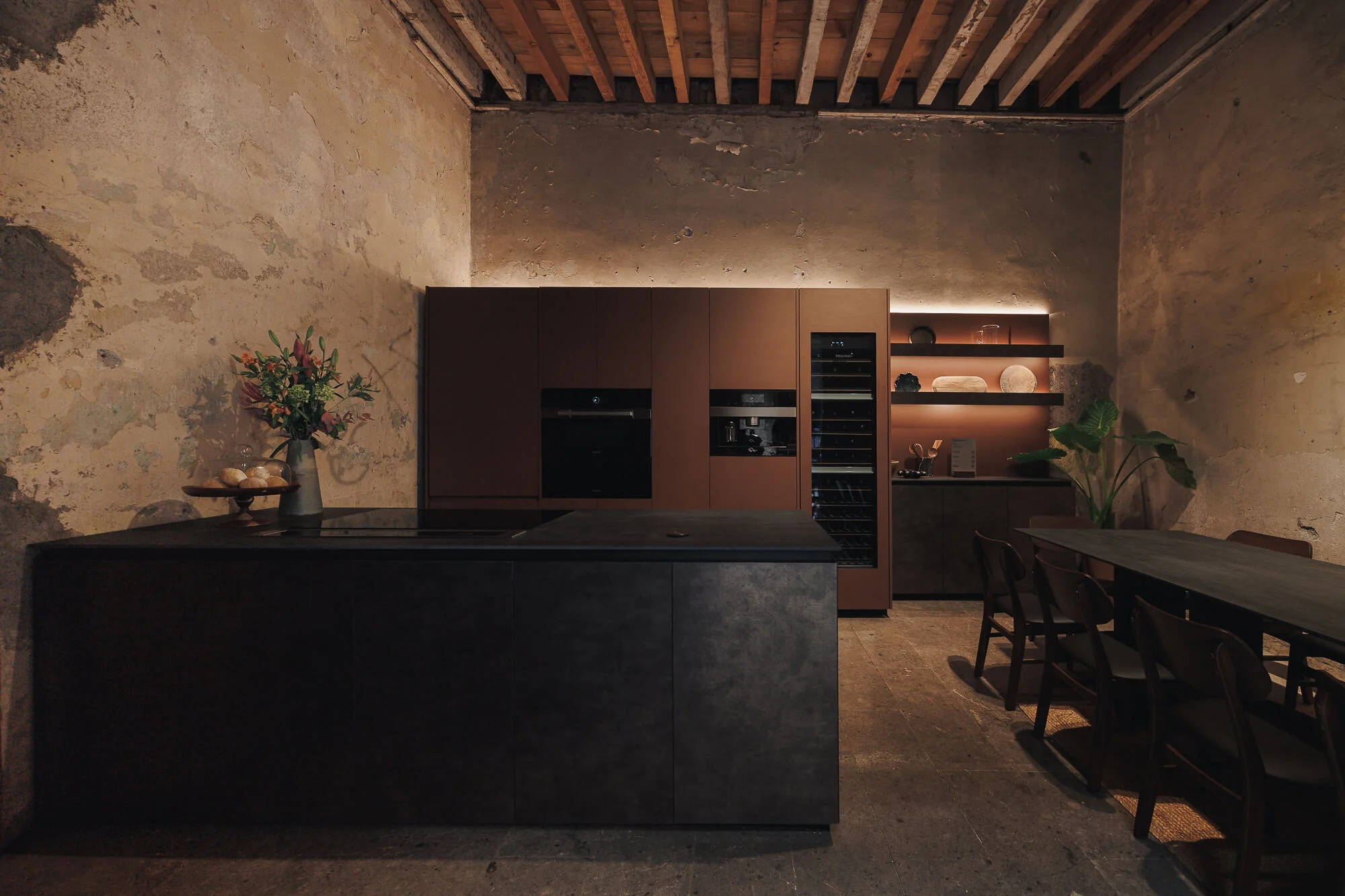 Front view of the Casa Taittinger kitchen with Cymisa metallic sheet island, 1905 Porfirian walls and exposed wooden beams — Vitelier at Proyecto Público Prim, Mexico City.