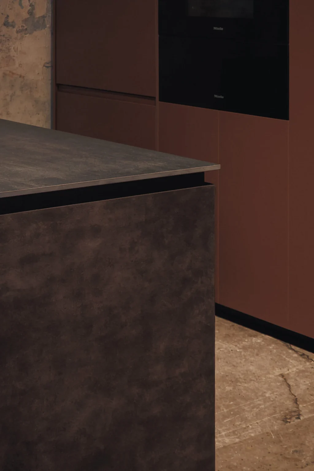 Island corner with Dekton Bromo countertop facing the Interforest copper laminate wall and Miele steam oven — design by Vitelier at Proyecto Público Prim.
