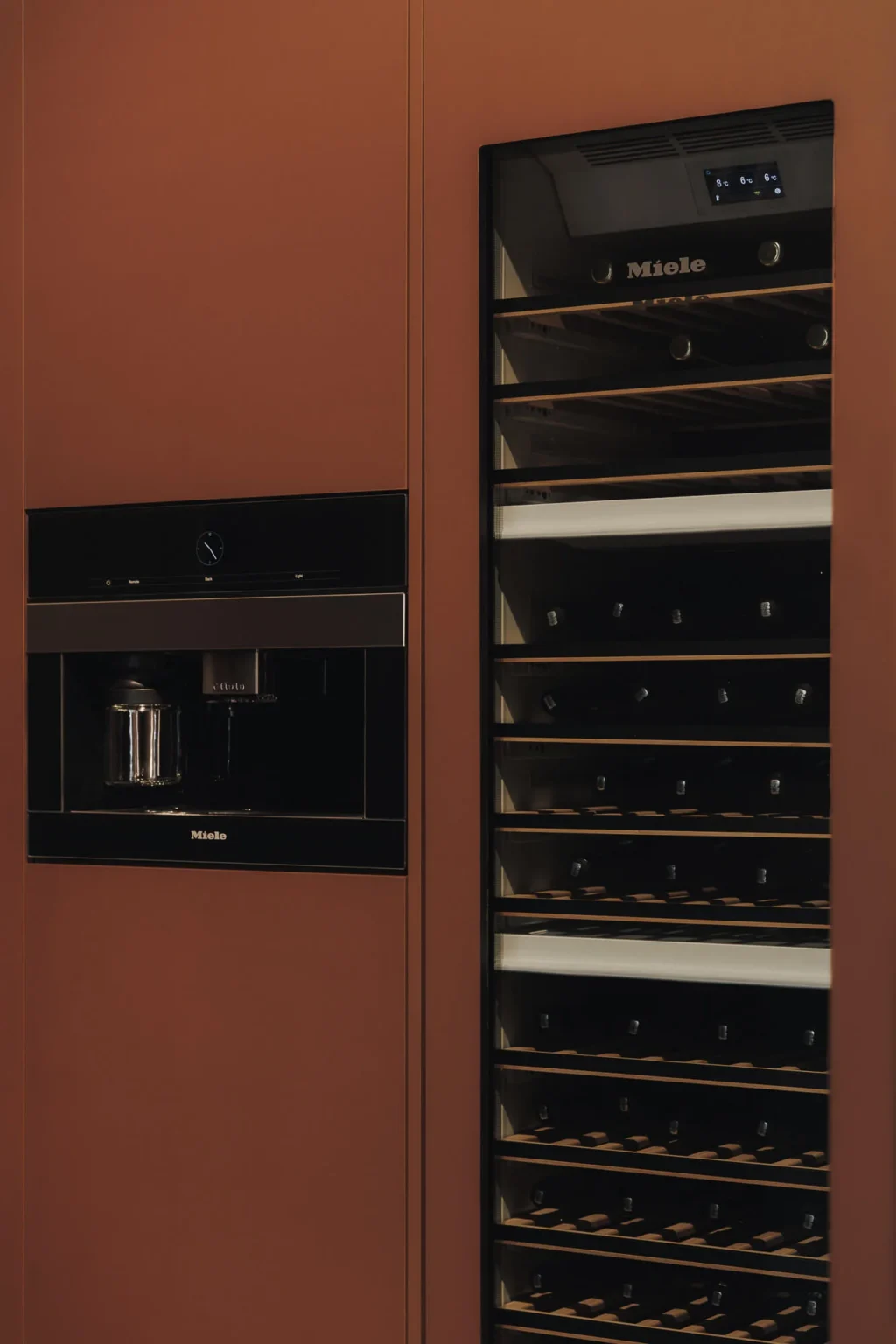 Miele MasterCool wine conditioner and built-in Miele coffee machine integrated into the Interforest copper laminate wall — Proyecto Público Prim.