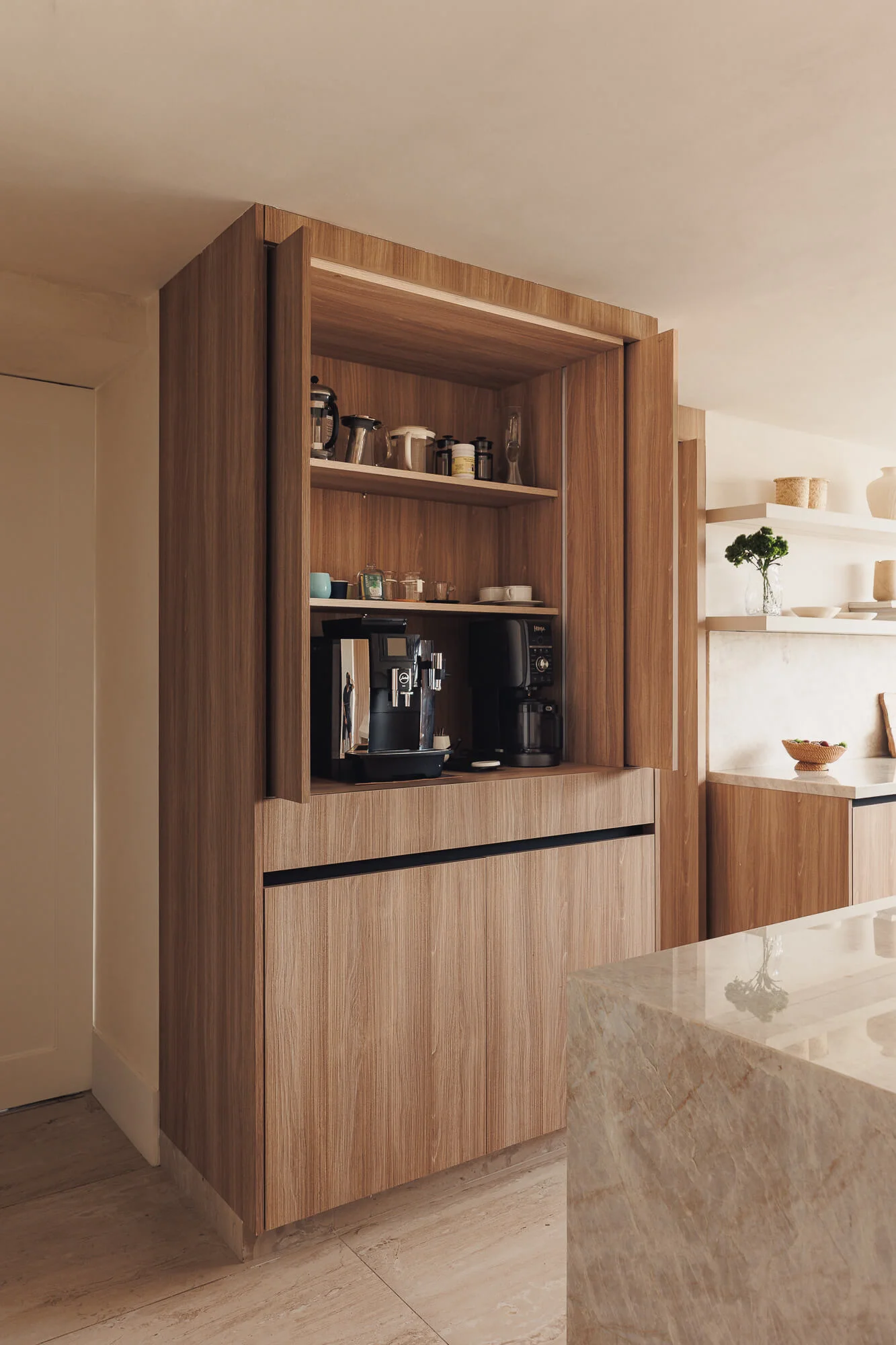 Estación de café con puertas retráctiles abierta, mostrando máquina de espresso Jura y cafetera dentro de torre Maple Samsara — almacenamiento integrado en cocina Vitelier CDMX.