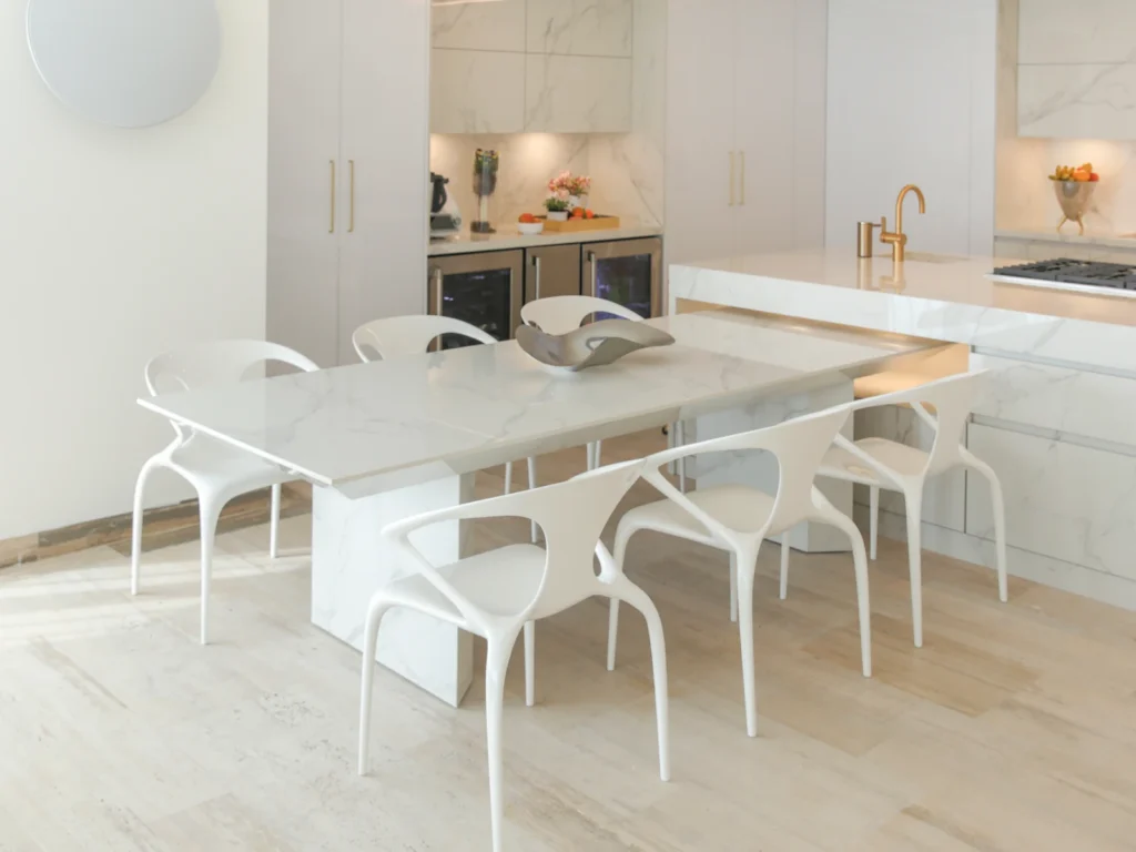 Mesa móvil en Dekton Natura separada de la isla con cavas de vino empotradas y alacenas al fondo en cocina de Acapulco.