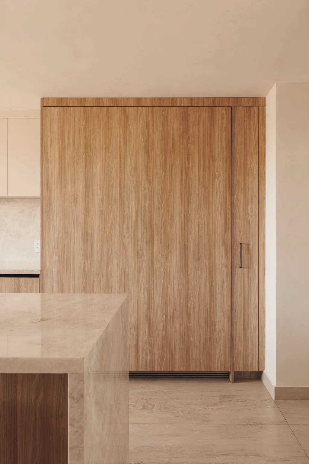 Refrigerador panelable cerrado, oculto tras una puerta de madera en melamina Maple Samsara, integrado a la línea de gabinetes — cocina a medida por Vitelier en Ciudad de México.