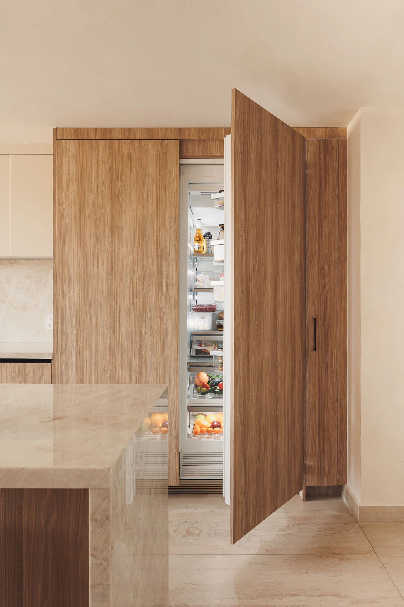 Refrigerador panelable abierto con la puerta de madera Maple Samsara descubierta, interior iluminado a plena altura — cocina a medida por Vitelier en Ciudad de México.