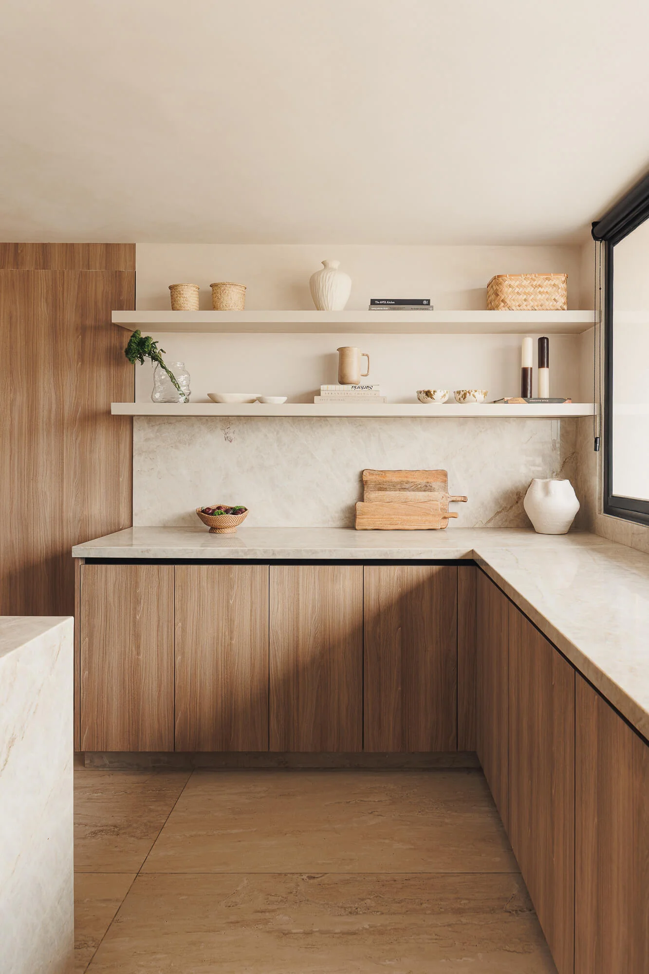 Repisas flotantes con tablas de madera, cestas tejidas y cerámica sobre backsplash de cuarcita Taj Mahal y gabinetes Maple Samsara — detalle de cocina Vitelier CDMX.