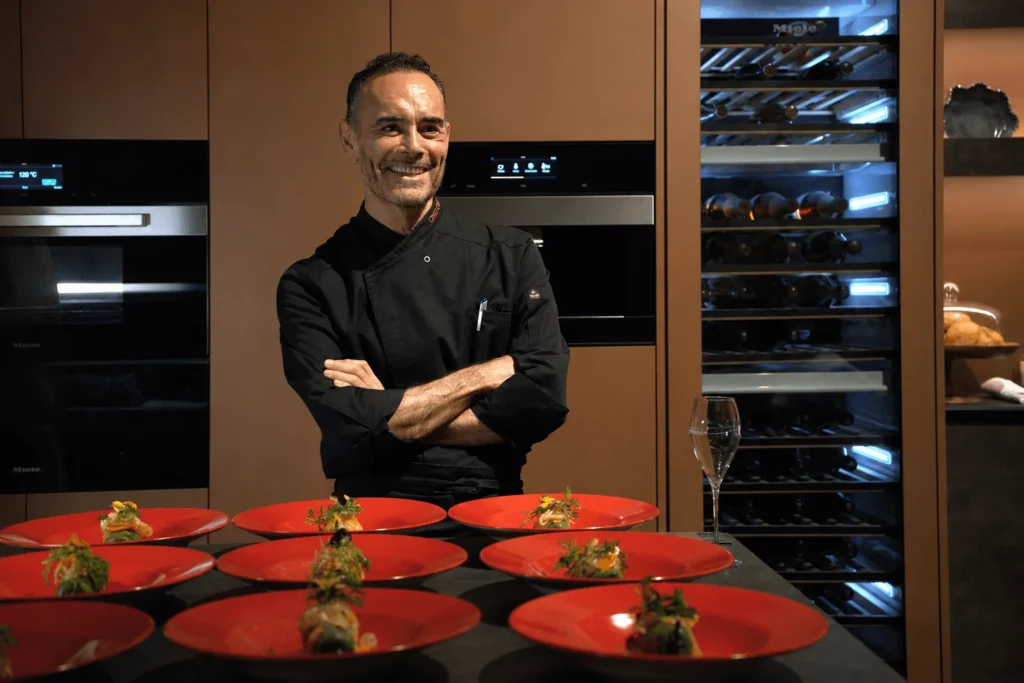 El chef Ricardo Muñoz Zurita junto a la cava de vinos Miele en Casa Taittinger, con platos ya emplatados